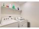 Laundry room with a Whirlpool washer and dryer and storage shelves at 2417 Mountain Sky Dr, Fort Lupton, CO 80621