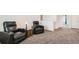 Cozy sitting area with carpet, recliner chairs, side table with lamp, and a view of the upper hallway at 2417 Mountain Sky Dr, Fort Lupton, CO 80621