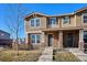 Tan two-story townhome with stone accents and a landscaped front yard at 10298 Tall Oaks Cir, Parker, CO 80134