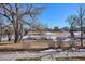 Landscaped yard with mature trees and snow at 10298 Tall Oaks Cir, Parker, CO 80134