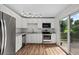 Modern kitchen featuring white cabinets, granite countertops, stainless appliances, and wood-look floors at 11823 Steele St, Thornton, CO 80233