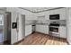 Modern kitchen featuring white cabinets, granite countertops, stainless appliances, and wood-look floors at 11823 Steele St, Thornton, CO 80233
