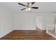 Bright room featuring wood-look floors, white walls, a ceiling fan, and staircase access at 11823 Steele St, Thornton, CO 80233