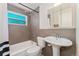 Updated bathroom showcasing gray tiled walls, modern fixtures, and a combination tub and shower at 1108 Roslyn St, Denver, CO 80220