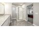 Bright bathroom showcasing a glass-enclosed shower and modern vanity, adjacent to a doorway with a bedroom view at 6777 Larsh Dr, Denver, CO 80221