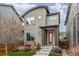 Contemporary two-story home with red front door, neat front yard landscaping, and modern design at 6777 Larsh Dr, Denver, CO 80221