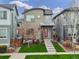 Modern two-story home with vibrant red door, landscaped front yard, and inviting curb appeal at 6777 Larsh Dr, Denver, CO 80221