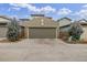 View of a two-car attached garage with a concrete driveway and manicured landscaping at 6777 Larsh Dr, Denver, CO 80221