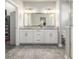 Main bathroom with double vanity, granite countertop, and shower at 6777 Larsh Dr, Denver, CO 80221