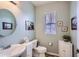 Charming half bath with stylish vanity, round mirror, and soft, neutral paint at 15226 W 93Rd Ave, Arvada, CO 80007