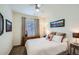 Comfortable bedroom featuring a ceiling fan, window, and mountain landscape art at 15226 W 93Rd Ave, Arvada, CO 80007
