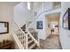 Bright foyer with staircase, neutral carpet, white railings, and artwork at 15226 W 93Rd Ave, Arvada, CO 80007