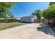 Large backyard featuring a concrete driveway, grassy area, and secure wooden gate, perfect for outdoor activities at 7111 Clermont St, Commerce City, CO 80022