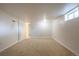 Spacious basement area with beige carpet and white walls, offering a versatile living space at 7111 Clermont St, Commerce City, CO 80022