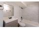 Well-lit bathroom features a modern sink, mirror, toilet and tiled shower with a dark bronze shower head at 7111 Clermont St, Commerce City, CO 80022