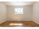 This bedroom features hardwood floors, neutral paint and a large window with natural light at 7111 Clermont St, Commerce City, CO 80022