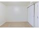 Beige bedroom features carpeted floors, white walls and a closet with two sliding doors at 7111 Clermont St, Commerce City, CO 80022