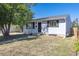 Attractive single-story home with gray siding, black shutters, and well-manicured front yard on a sunny day at 7111 Clermont St, Commerce City, CO 80022