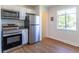 Modern kitchen with stainless steel appliances, white cabinets, hardwood floors, and ample natural light at 7111 Clermont St, Commerce City, CO 80022