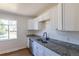 Stylish kitchen with white cabinets, granite countertops, stainless steel dishwasher, and hardwood flooring at 7111 Clermont St, Commerce City, CO 80022