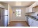 Bright kitchen featuring white cabinets, granite countertops, stainless steel appliances, and hardwood floors at 7111 Clermont St, Commerce City, CO 80022