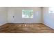 Sunlit living room features hardwood floors and a large window with backyard views at 7111 Clermont St, Commerce City, CO 80022