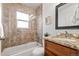 The full bathroom features stone tile, a shower, and granite counters on the vanity at 2551 N Glencoe St, Denver, CO 80207