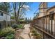 Beautiful backyard garden with stone pathway, professional landscaping, wooden fence, and a raised wood deck at 851 Racquet Ln, Boulder, CO 80303