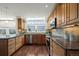 Open kitchen boasting stainless steel appliances, granite countertops, and wooden cabinets at 851 Racquet Ln, Boulder, CO 80303