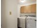 Functional laundry room with washer, dryer, storage cabinets, and lighting at 851 Racquet Ln, Boulder, CO 80303