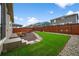 Beautiful backyard featuring artificial grass, a firepit, and outdoor seating at 452 S Norfolk Ct, Aurora, CO 80017