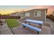Inviting backyard with stone patio, green turf, picnic table, and manicured landscaping for relaxing outdoor enjoyment at 452 S Norfolk Ct, Aurora, CO 80017