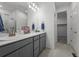 Spacious bathroom boasts double sinks with gray cabinets and bright vanity lighting at 452 S Norfolk Ct, Aurora, CO 80017