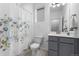 Bright bathroom with floral shower curtain, gray vanity, modern fixtures, and a large mirror at 452 S Norfolk Ct, Aurora, CO 80017