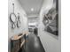 Inviting hallway with hardwood floors, decorative mirrors, and artwork leads to the open living area at 452 S Norfolk Ct, Aurora, CO 80017