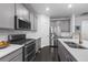Modern kitchen featuring gray cabinetry, stainless steel appliances, and gas range at 452 S Norfolk Ct, Aurora, CO 80017