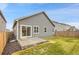 Exterior view of the home features well-maintained backyard with lawn, concrete patio, and secure wood fence at 239 Chipeta Way, Lochbuie, CO 80603