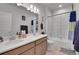 Modern bathroom featuring a double sink vanity, and a shower-tub combination with white tile surround at 239 Chipeta Way, Lochbuie, CO 80603