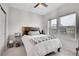 Bright bedroom featuring a cozy bed with a wooden headboard, two windows, and neutral-toned walls at 239 Chipeta Way, Lochbuie, CO 80603