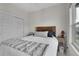 Bright bedroom featuring a cozy bed with a wooden headboard, two windows, and neutral-toned walls at 239 Chipeta Way, Lochbuie, CO 80603