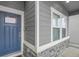 Close-up view of a home's front entrance, highlighting the blue door, stone accents, and modern siding at 239 Chipeta Way, Lochbuie, CO 80603