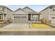 Charming single-Gathering home showcasing gray siding, stone accents, a well-manicured lawn, and an attached two-car garage at 239 Chipeta Way, Lochbuie, CO 80603