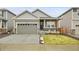 Charming single-Gathering home showcasing gray siding, stone accents, a well-manicured lawn, and an attached two-car garage at 239 Chipeta Way, Lochbuie, CO 80603