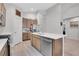 Kitchen featuring quartz countertops, stainless steel appliances, hardwood floors, and breakfast bar at 239 Chipeta Way, Lochbuie, CO 80603