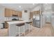 Modern kitchen featuring stainless steel appliances, a center island with seating, and ample cabinet space at 239 Chipeta Way, Lochbuie, CO 80603