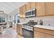 Modern kitchen with stainless steel oven and microwave, light countertops, and access to the living room at 239 Chipeta Way, Lochbuie, CO 80603