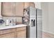 Kitchen features stainless steel refrigerator, white countertops, and light brown cabinets at 239 Chipeta Way, Lochbuie, CO 80603