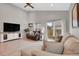 Comfortable living room features vaulted ceiling, large windows, and sliding door access to the backyard at 239 Chipeta Way, Lochbuie, CO 80603