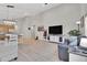 Spacious living area featuring a large TV, comfortable seating, and a dining area with unique lighting fixture at 239 Chipeta Way, Lochbuie, CO 80603