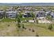Aerial view of the back of a modern house with a sport court, and green lawn at 10826 Evergold Way, Highlands Ranch, CO 80126